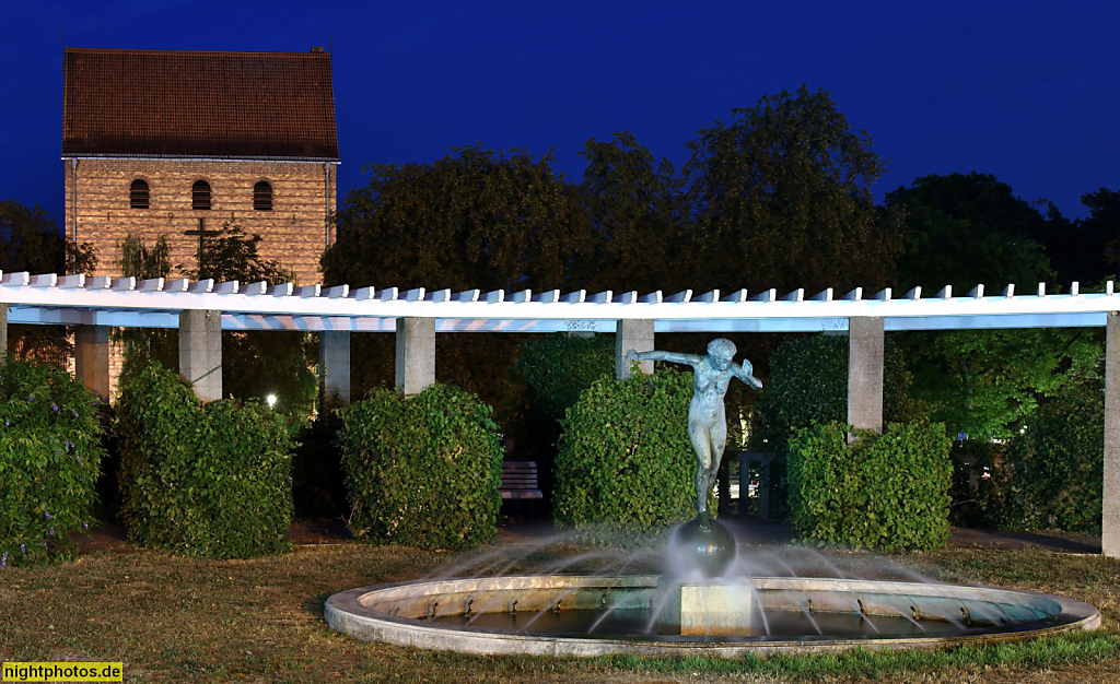 Berlin Frohnau Zeltinger Platz. Johanneskirche erbaut 1934-1937. Bronzeskulptur 'Die Kugelläuferin' von Otto Maerker. 1980 nachgebildet von Harald Haake