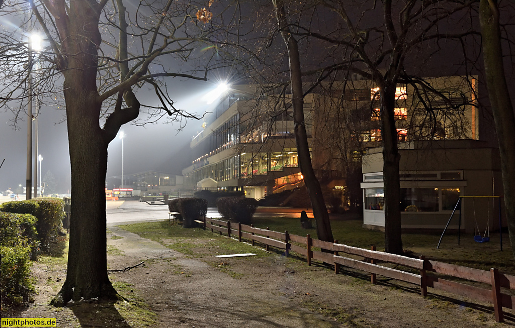 Berlin Trabrennbahn Mariendorf. Tribünenhaus Neubau erbaut 1972 von Moratz und Vogel bei Stolze und Partner. Haupttribüne bei Flutlicht. Hirzer Weg 47–109