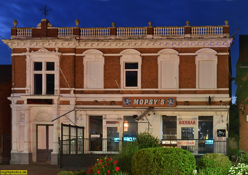 Burg auf Fehmarn. Bierbar. Teilverputzte Backsteinfassade mit Dachbalustrade und Konsolgesims. Seitenrisalit mit Säulenportikus. Bahnhofstrasse 3