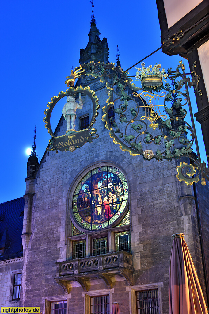Quedlinburg. Rathaus erbaut ab 1300 aus Werkstein. Rundfenster mit Glasgemälde erschaffen 1901 von Ferdinand Müller. Namenszeichen von Cafe Roland mit Roland Statue. Breite Strasse 1